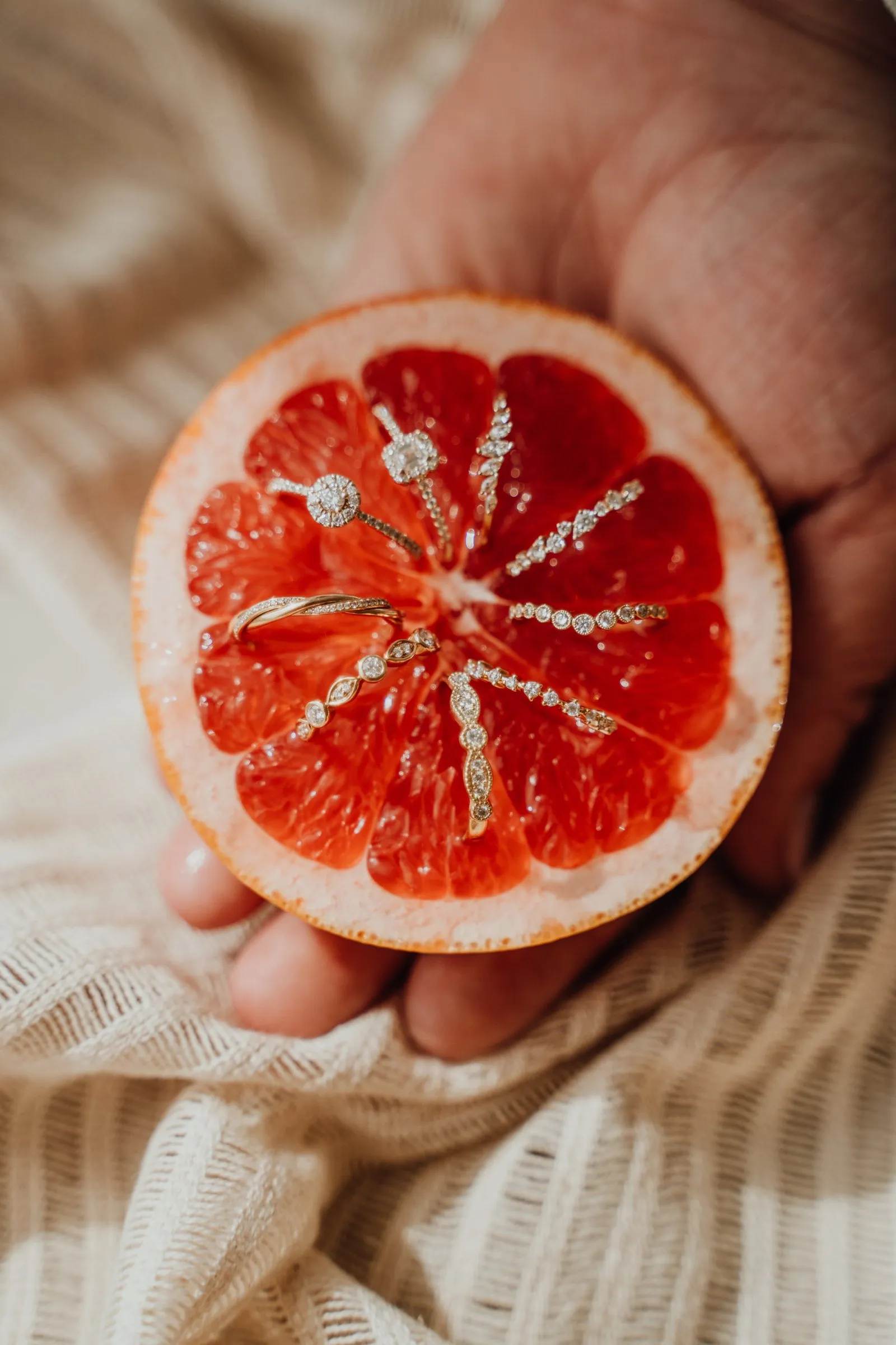 Zarte Ringe mit Diamanten in einer halben Grapefruit
