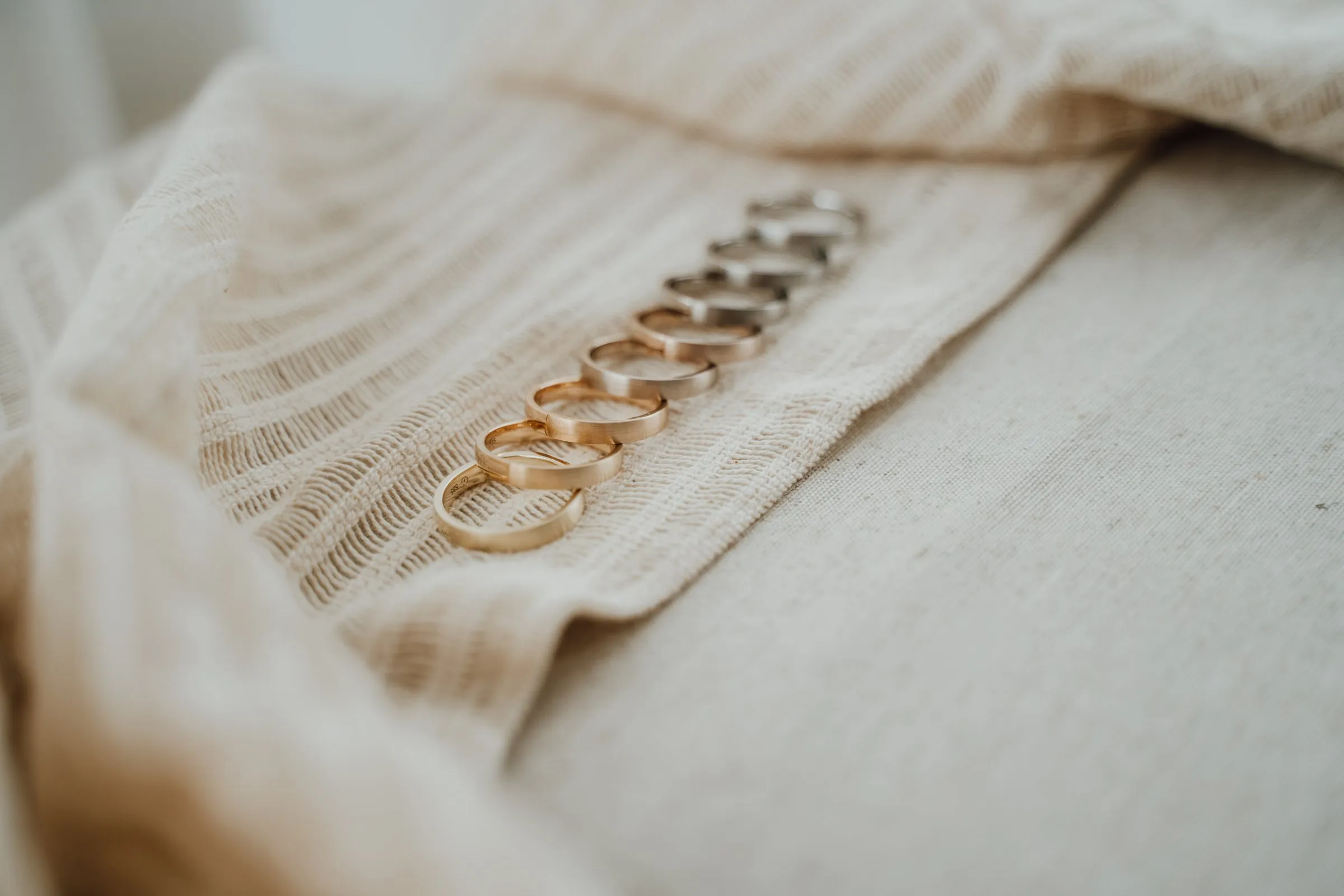 Reihe von Ringen in Gelbgold und Weißgold auf Leinen